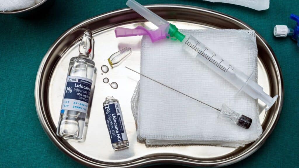 Anesthesia agents on a stainless steel surgical instrument tray representing malpractice.